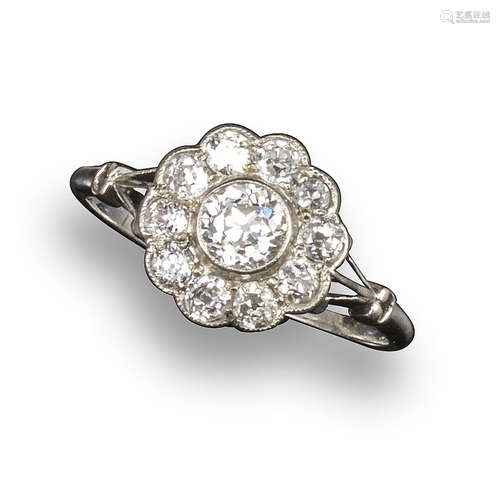 An Edwardian diamond cluster ring, the old circular-cut diamond set within a surround of ten smaller