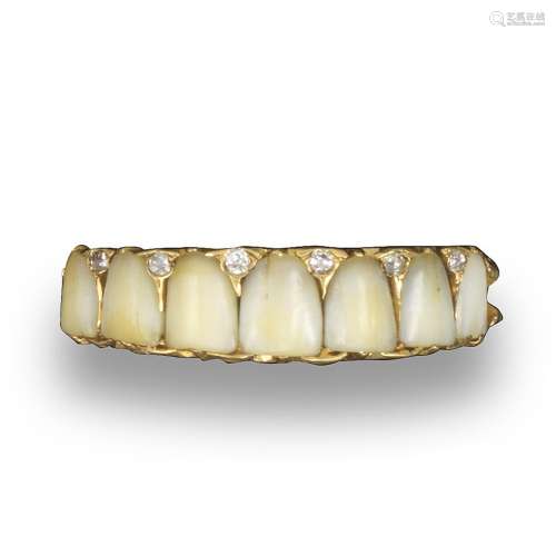 A late Victorian novelty ring, set with seven small children's teeth, the teeth separated with small