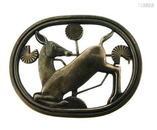 A silver deer brooch by Georg Jensen, design 256, the deer kneeling amongst tall flowers, maker's