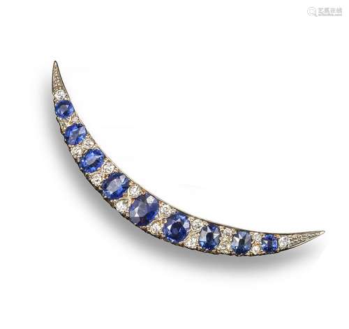 An Edwardian sapphire and diamond-set open crescent brooch, set with graduated oval-shaped sapphires