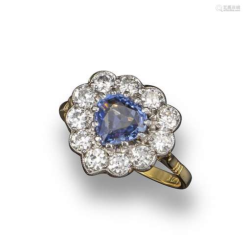 A sapphire and diamond-set heart-shaped ring, the sapphire set within a surround of eleven old