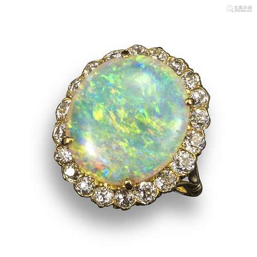 An opal and diamond cluster ring, the oval-shaped white opal set within a surround of twenty