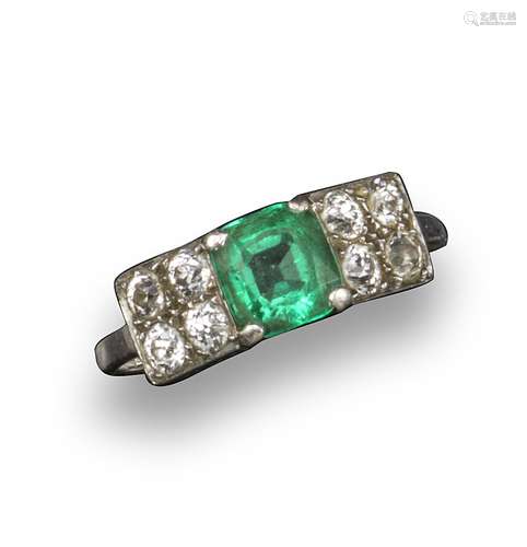 An emerald and diamond ring, the cushion-shaped emerald set with four circular-cut diamonds to