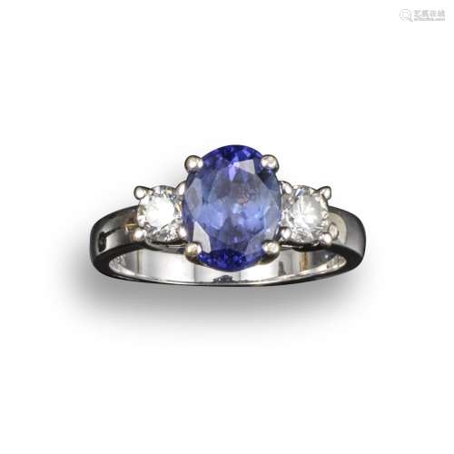 A tanzanite and diamond three-stone ring, the oval-shaped tanzanite set with two round brilliant-cut
