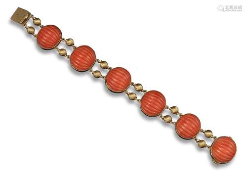 A coral and yellow gold bracelet, the six slightly oval sections of fluted coral are mounted in