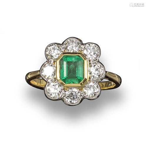 An emerald and diamond cluster ring, the octagonal-cut emerald set within a surround of old