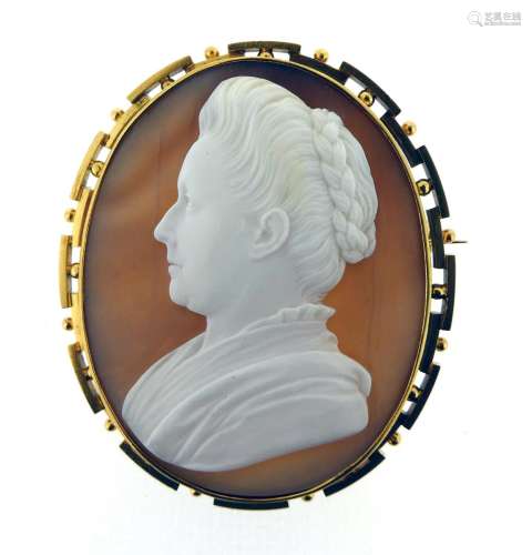 A Victorian shell cameo brooch, depicting a woman in profile within abstract linear and pellet