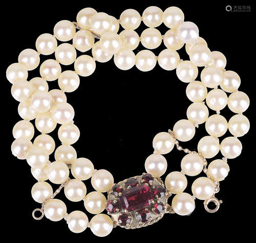 A three row cultured pearl bracelet with garnet set clasp