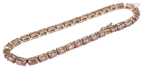 A 9ct gold mounted garnet set line bracelet