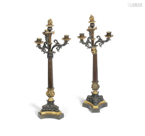 A pair of Charles X patinated bronze and parcel gilt four light candelabra