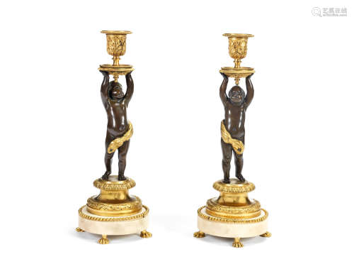 A pair of 19th century and later patinated and gilt bronze and white marble figural figural candlesticks