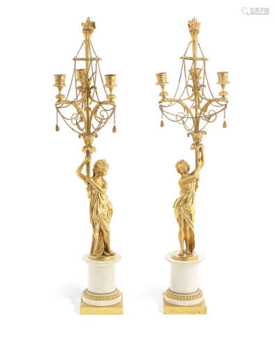 in the Louis XVI style A pair of gilt bronze and white marble figural three light candelabra