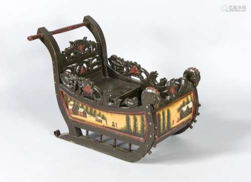 An early 20th-cenrtury child´s sleigh, wood polychromed red and brown, the