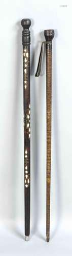 Two walking sticks, one shaft compounded with leather-slabs and hand strap,