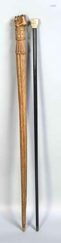 Two walking sticks with fist handles, one ebonized wood shaft with bone fis