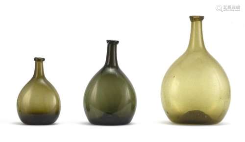 THREE FREE-BLOWN GLASS CHESTNUT BOTTLES In green. Heights from 6.75