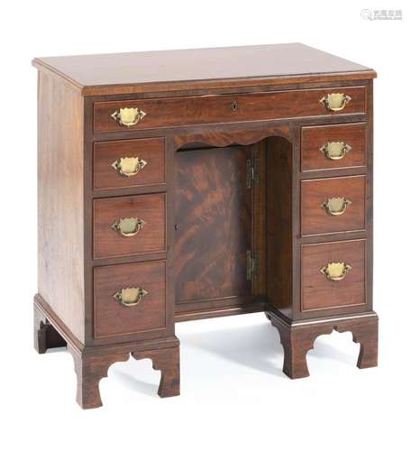 KNEEHOLE DESK In walnut. Full-width drawer across top and three drawers on each side of kneehole. All seven drawers with brass bail...