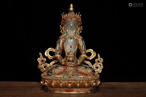 A GILT BRONZE BUDDHA DESIGN FIGURE WITH CRYSTAL