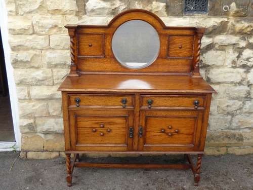 An Oak Sideboard with back panel having a round mirror