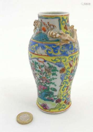 A Chinese Cantonese famille jaune vase of baluster form, having moulded gil