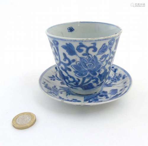 A Chinese blue and white cup and saucer, the cup decorated with lotus flowe