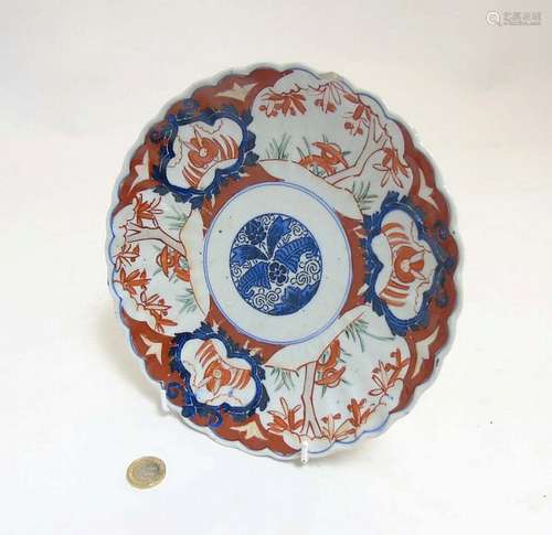 An Oriental Imari style plate with scalloped edges with stylized floral des