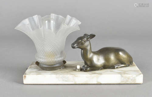 An art deco spelter and marble table lamp, the frosted, crimped shade surmounted by seated deer,