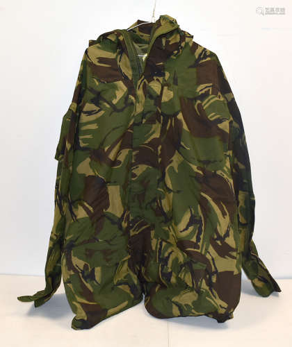 An assortment of Army clothing, including a Smock Combat, other hooded jackets, in camo and olive, a