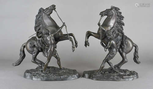 A pair of 20th Century re casts of bronze Marley Horses, after Couston, on oval naturalistic