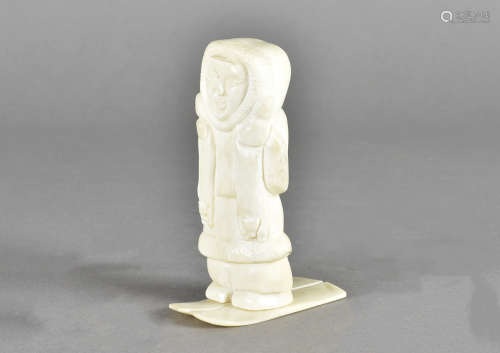 An inuit bone carving, of a hunter on skis with two arctic foxes, 11 cm high