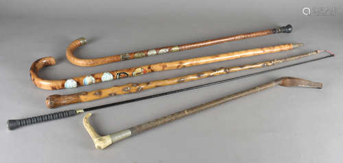 Three alpine walking sticks, with applied badges together with an antler handled riding crop and