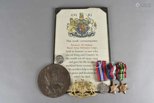 A group of three WWII medal and scroll, awarded to PTE G.W. HOLMES of the Royal Army Ordnance Corps,