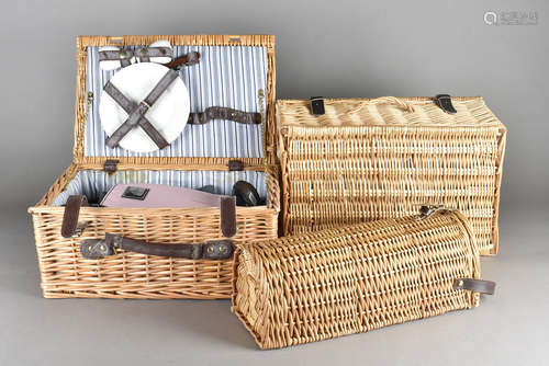 A collection of wicker picnic baskets, including one with fitted interior, two champagne bottle