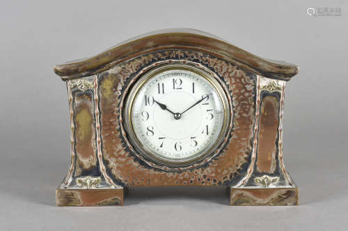 An arts and crafts silver plated mantel clock, French drum movement, arabic numerals to white