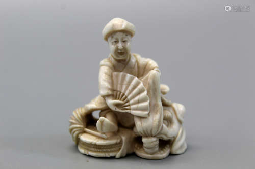 A Japanese carved figurine of an old man.