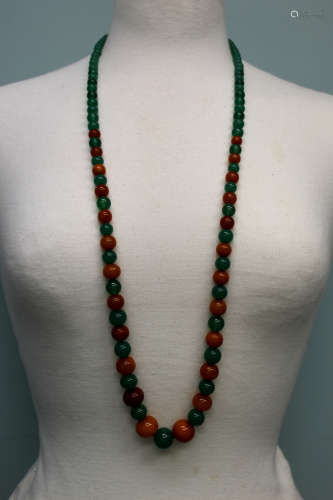 A amber color beads and green glass beads necklace.