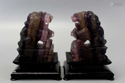 Pair carved amethyst fu lions raised on wood stands.