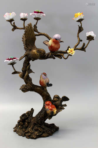 A bronze tree with porcelain birds and flowers.