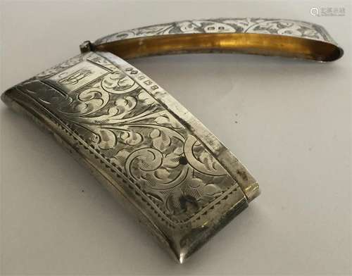 A silver hinged top card case with scroll decorati