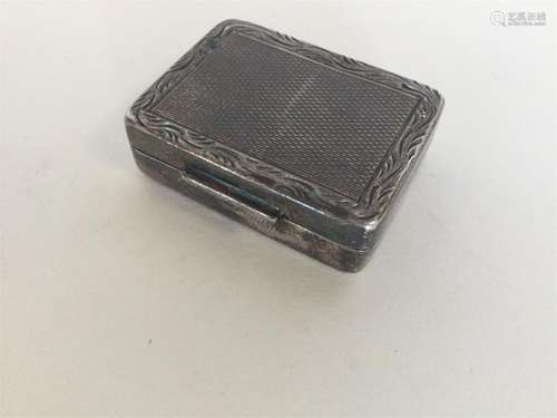 A small silver modern rectangular pill box with eng