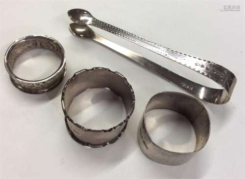 A group of four silver napkin rings together with