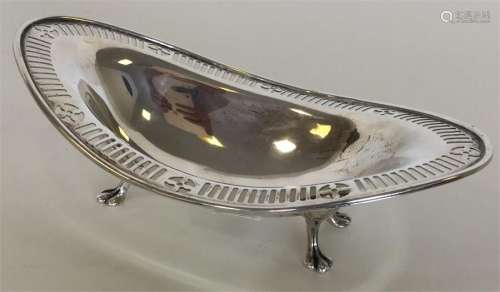 An Edwardian boat-shaped silver dish on four feet.