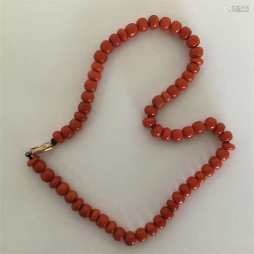 A string of coral beads with gold barrel clasp. Ap