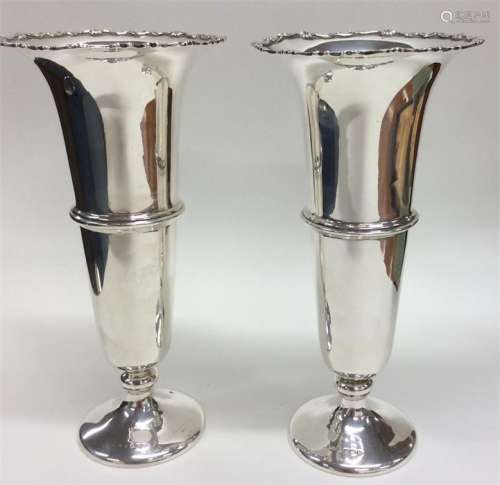 A pair of silver tapering spill vases with wavy ed