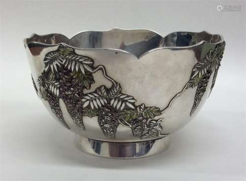 An Oriental silver bowl with enamel foliage on ped