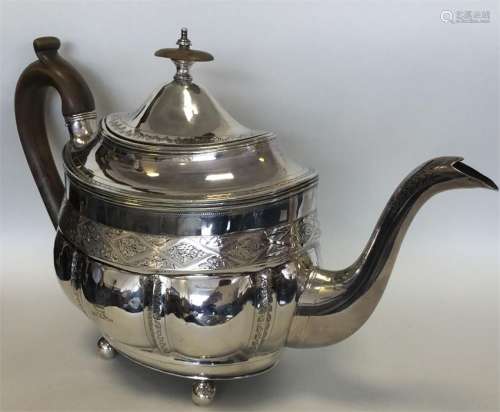A Georgian silver bright cut teapot on ball feet.