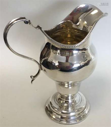 A Georgian-style silver helmet shaped cream jug wi