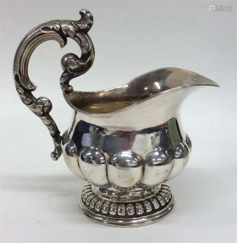 A stylish Continental silver cream jug with cast h