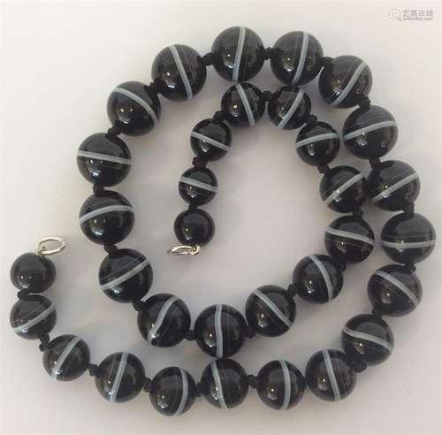 A graduated string of banded agate beads. Approx.