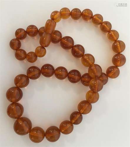 A graduated string of circular amber beads with co